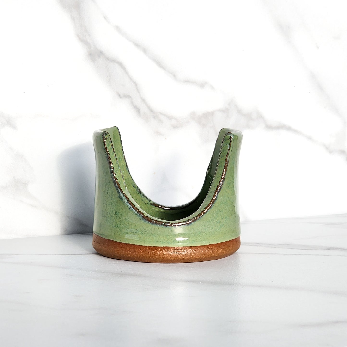 Image: Clinton Pottery's Handmade Sponge Holder in Bud Green – A visually appealing and practical kitchen accessory crafted with artisanal expertise. This durable stoneware holder in refreshing Bud Green, reminiscent of spring foliage and new growth, adds a touch of nature's vitality to your kitchen. Designed to hold your sponge securely and prevent water from spreading, it keeps your counters and sink area tidy.