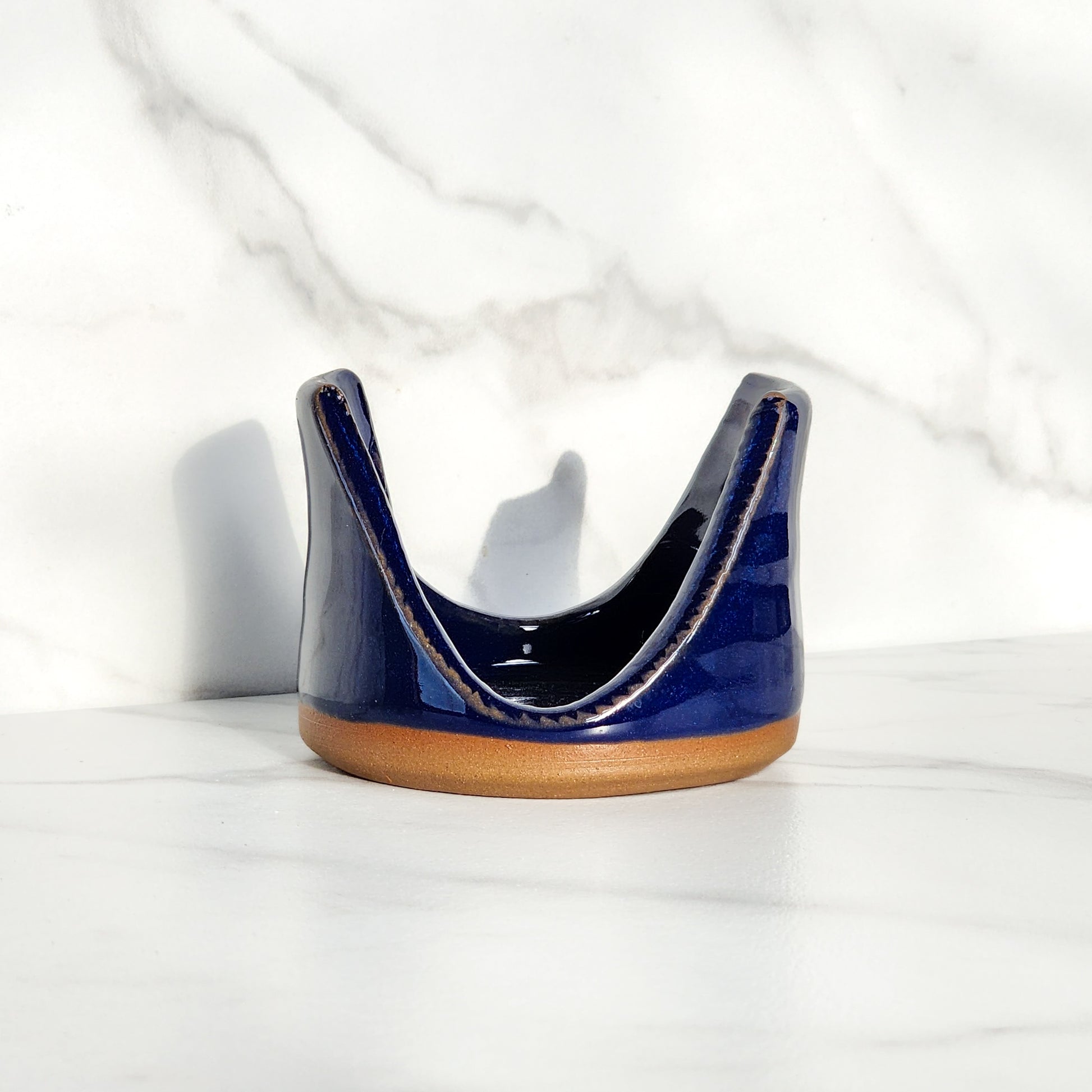 Image: Clinton Pottery's Handmade Sponge Holder in Cobalt Blue – A bold and practical kitchen accessory, meticulously crafted by artisans. This durable stoneware holder, in striking Cobalt Blue, adds a touch of vibrant sophistication to your kitchen, reminiscent of deep blue ocean depths and timeless elegance. Designed to securely hold your sponge and prevent water spread, it keeps your counters and sink area tidy. 