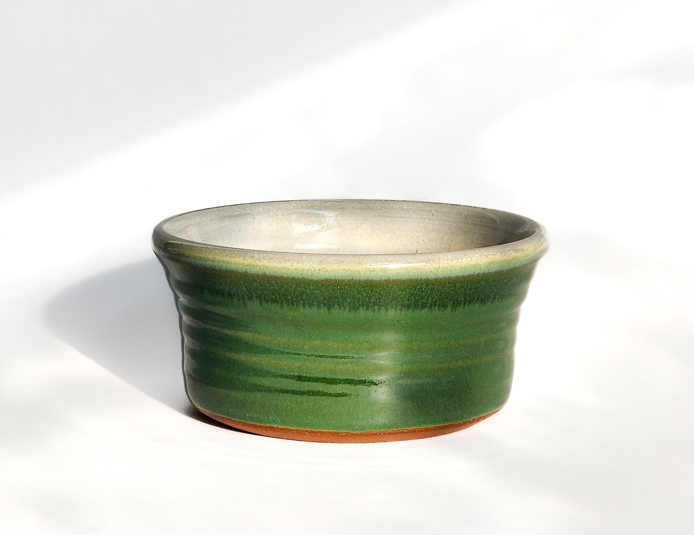 Image: Clinton Pottery's Handmade 1 Cup Flat Bottom Bowl in Dark Green – A subtle nod to nature's richness, this machine washable bowl seamlessly blends artistry with practicality. The deep dark green color evokes the tranquility of lush forests and foliage. Perfect for serving snacks or infusing your space with a touch of natural elegance and versatility.