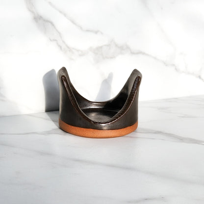  Image: Clinton Pottery's Handmade Sponge Holder in Licorice – A sleek and practical kitchen accessory, impeccably crafted by artisans. This durable stoneware holder, in sophisticated Licorice, brings a touch of modern elegance to your kitchen. Designed to securely hold your sponge and prevent water spread, it keeps your counters and sink area tidy. 